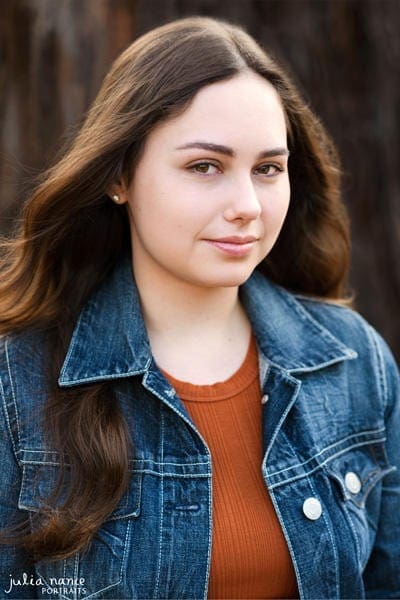 Melbourne actor headshot of brunette girl with long hair and slight smile - wearing denim jacket