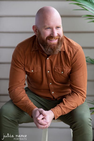 Melbourne corporate headshot photography and personal branding portraits. Candid portrait of man smiling while sitting outdoors.