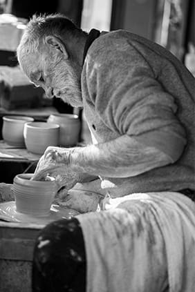 Portrait of professional potter Graeme Anderson in Lightning Ridge while on his pottery wheel