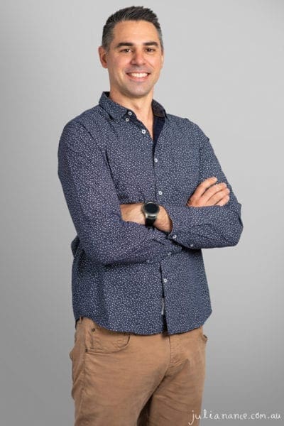 Personal branding corporate portrait of man wearing formal shirt on a grey background.