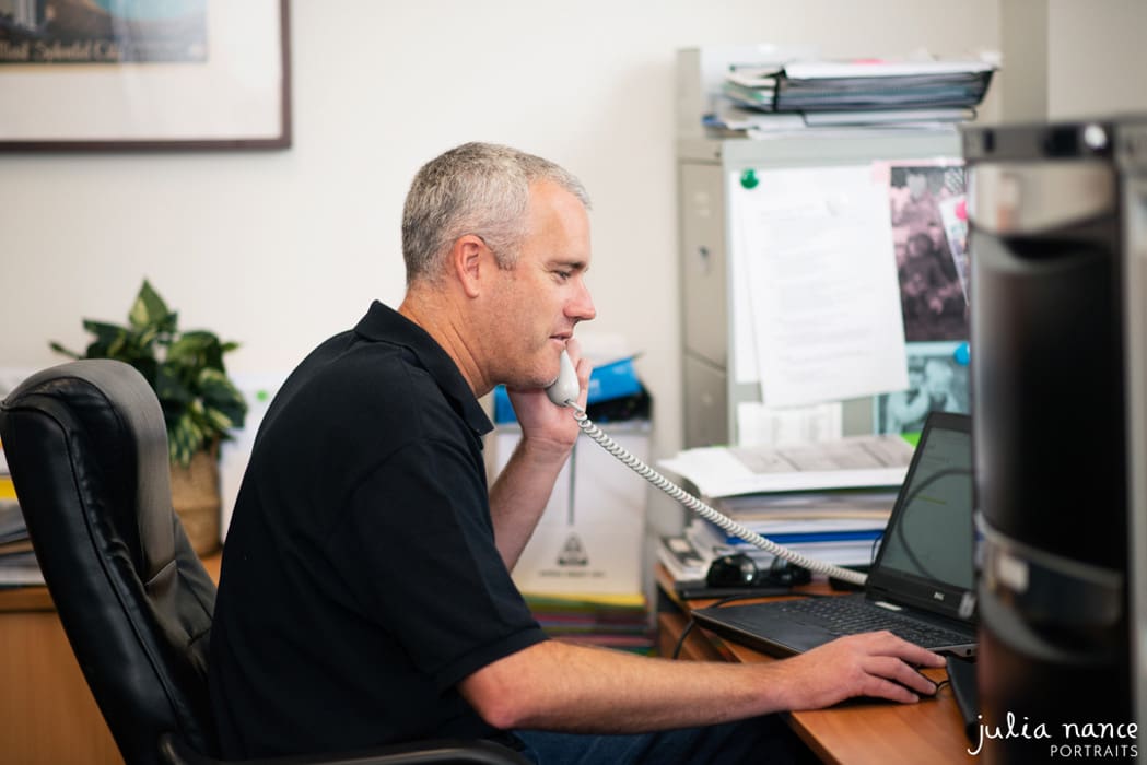 Personal branding photography of an office worker on the phone. On-site corporate portrait photograph taken by Julia Nance Portraits