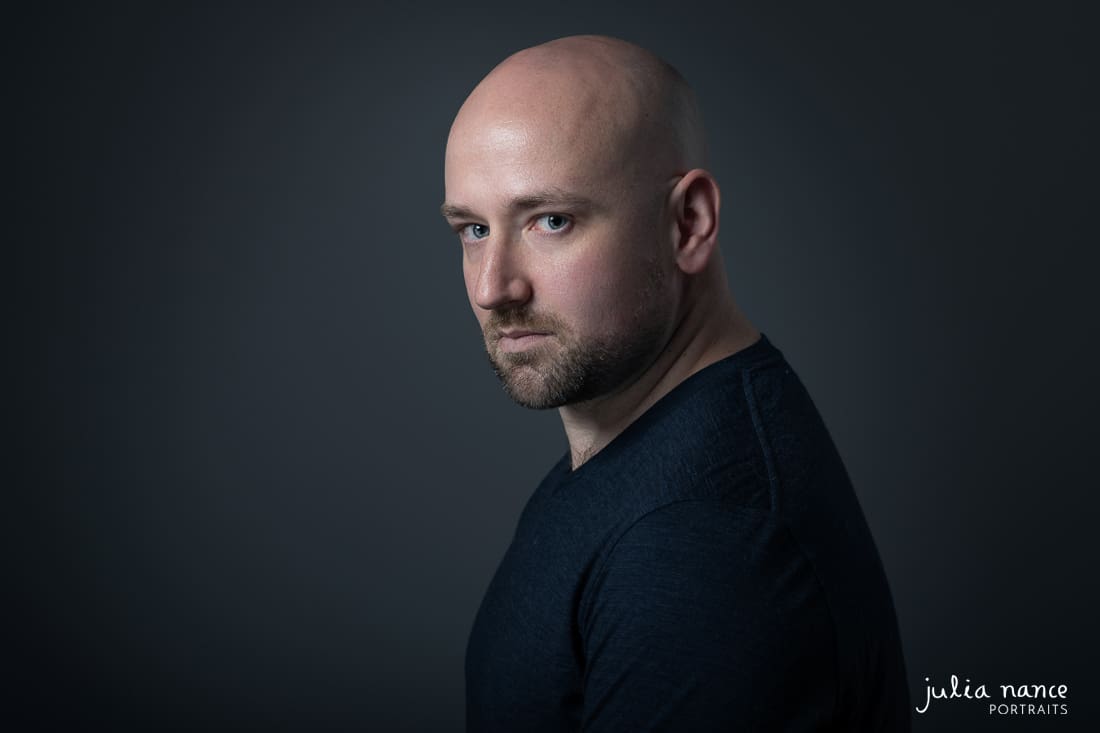 Man looks over his shoulder in serious actor headshot.