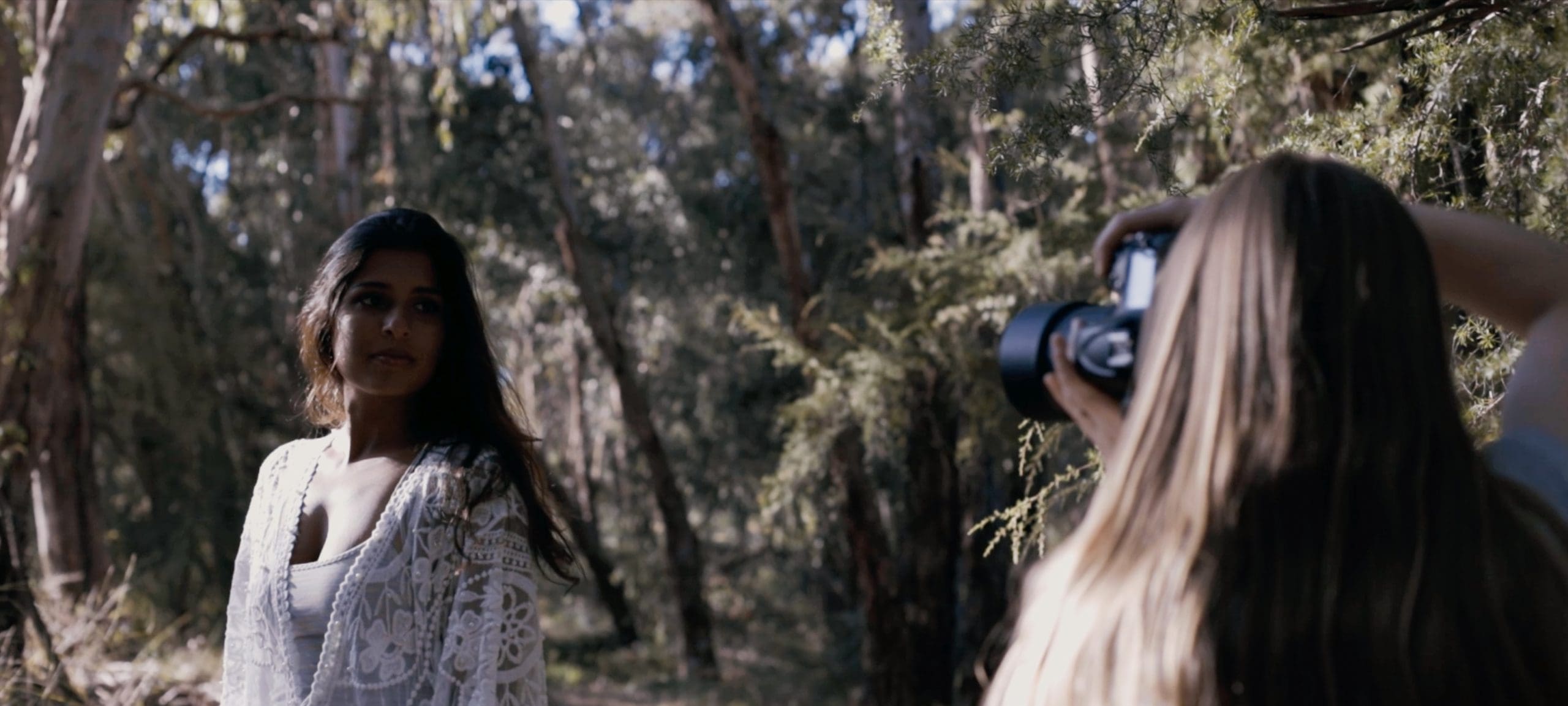 Behind the scenes image of Julia photographing a model outdoors.