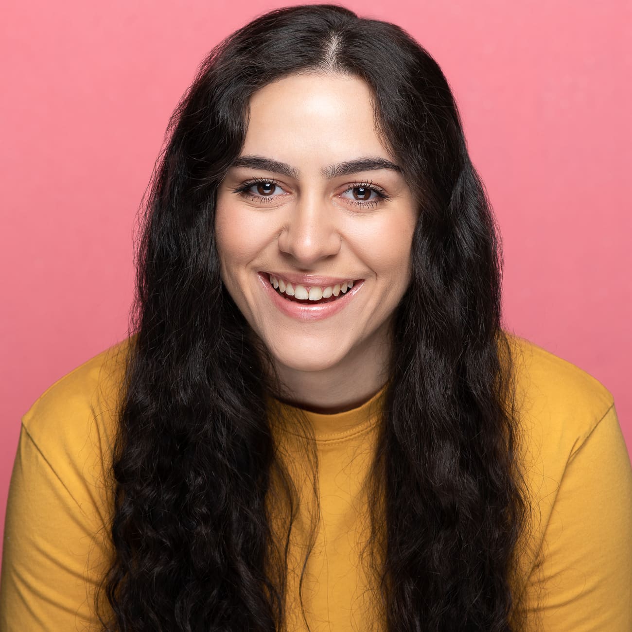 Melbourne actor laughs to camera wearing bright yellow.