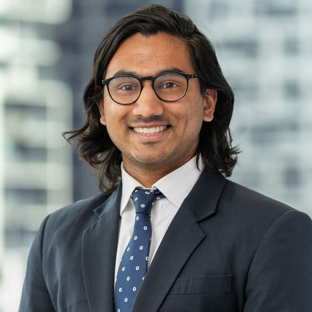 Corporate staff headshot of melbourne lawyer with city skyline background.