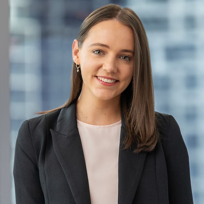 Corporate staff headshot of melbourne lawyer with city skyline background.