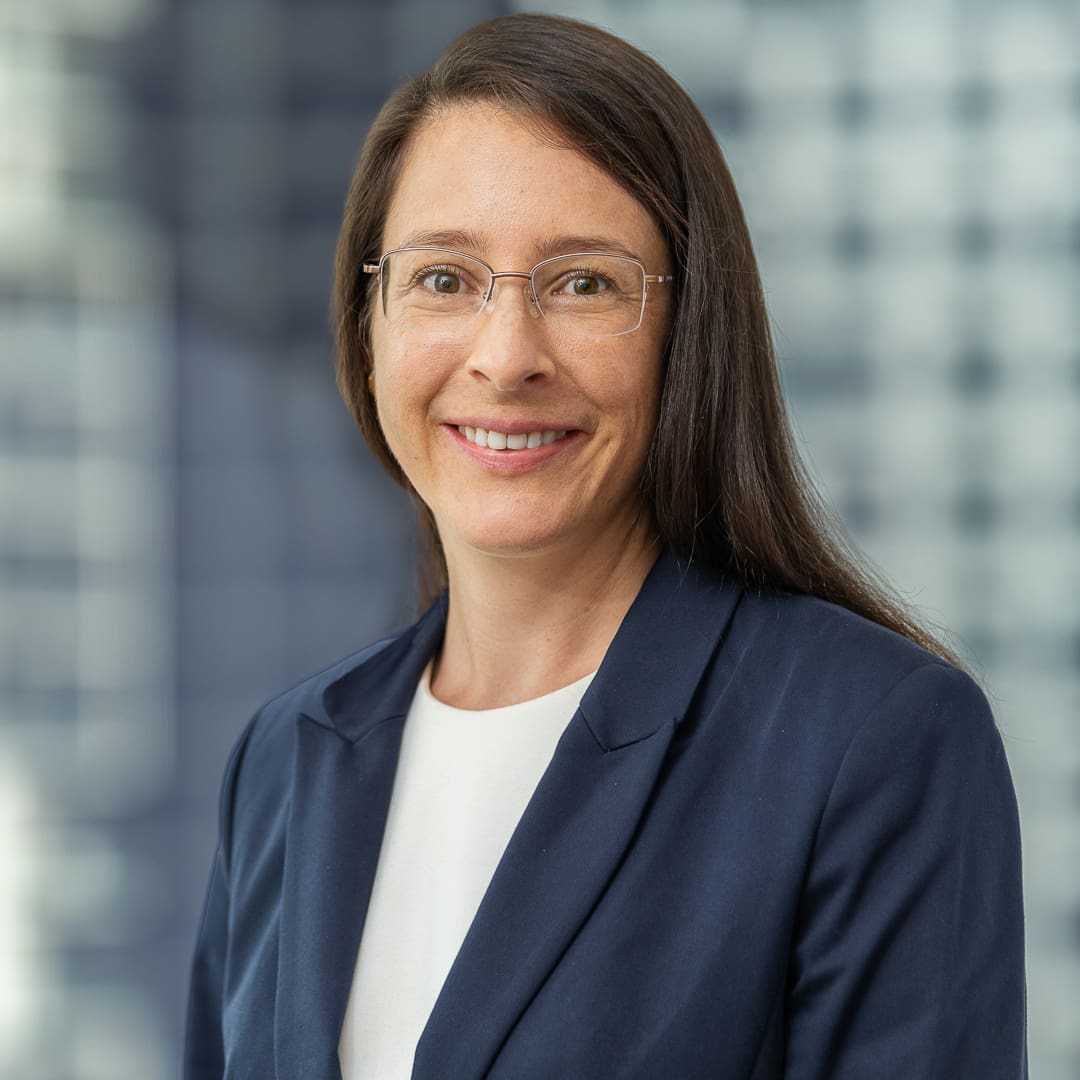 Corporate staff headshot of melbourne lawyer with city skyline background.