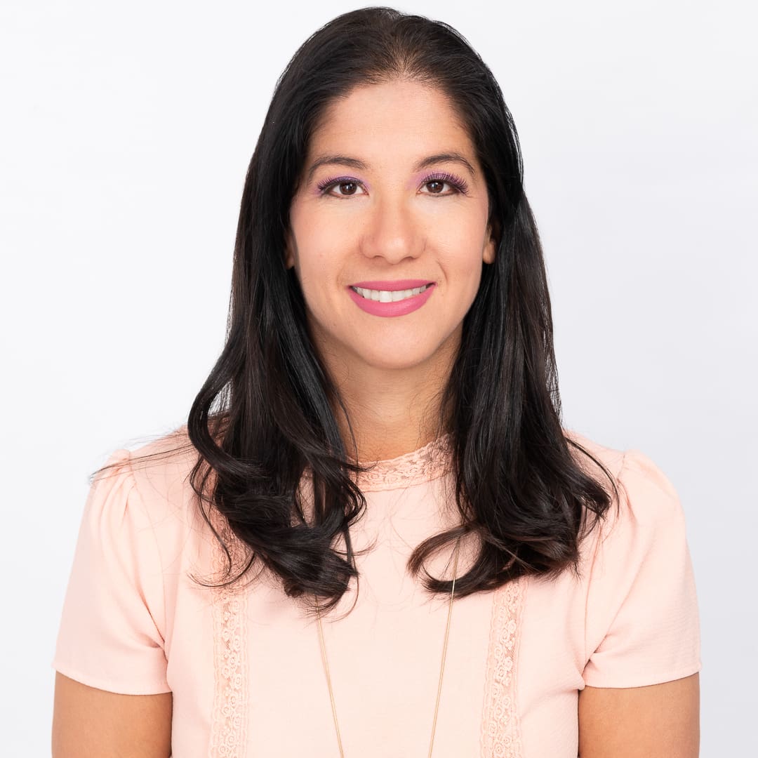 Woman photographed in studio for personal branding headshot smiles to camera.