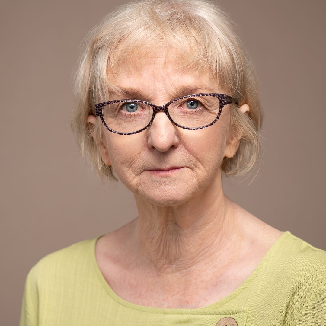 Mature actor looks to camera in serious actor headshot update taken in studio