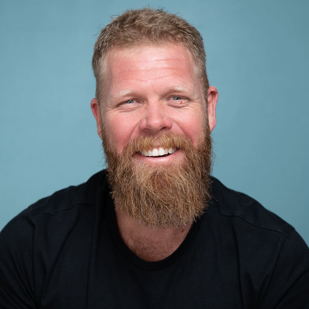 Melbourne actor smiles to camera on blue studio background for actor headshot update.