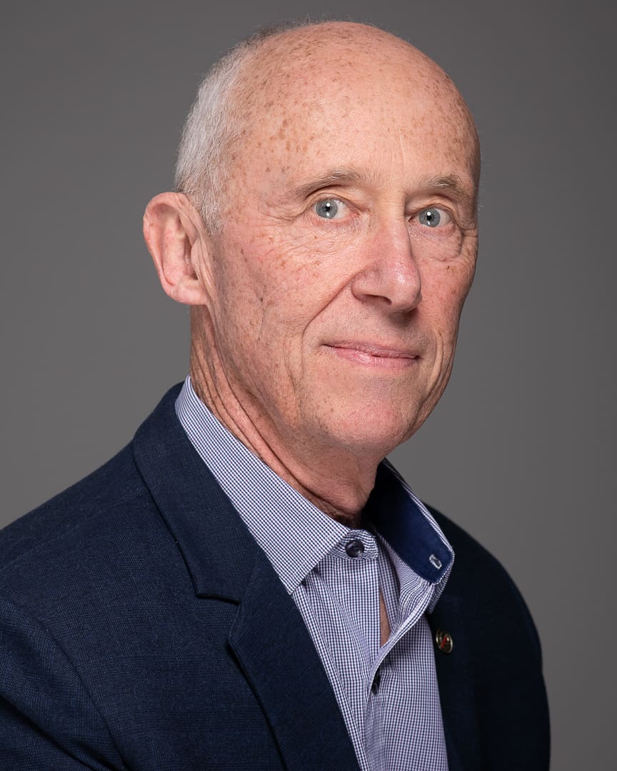 Professional headshot of Melbourne business owner on a grey background in studio.