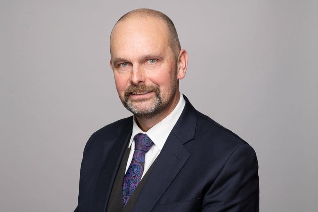 Melbourne barrister headshot of man smiling to camera wearing a suit and tie.