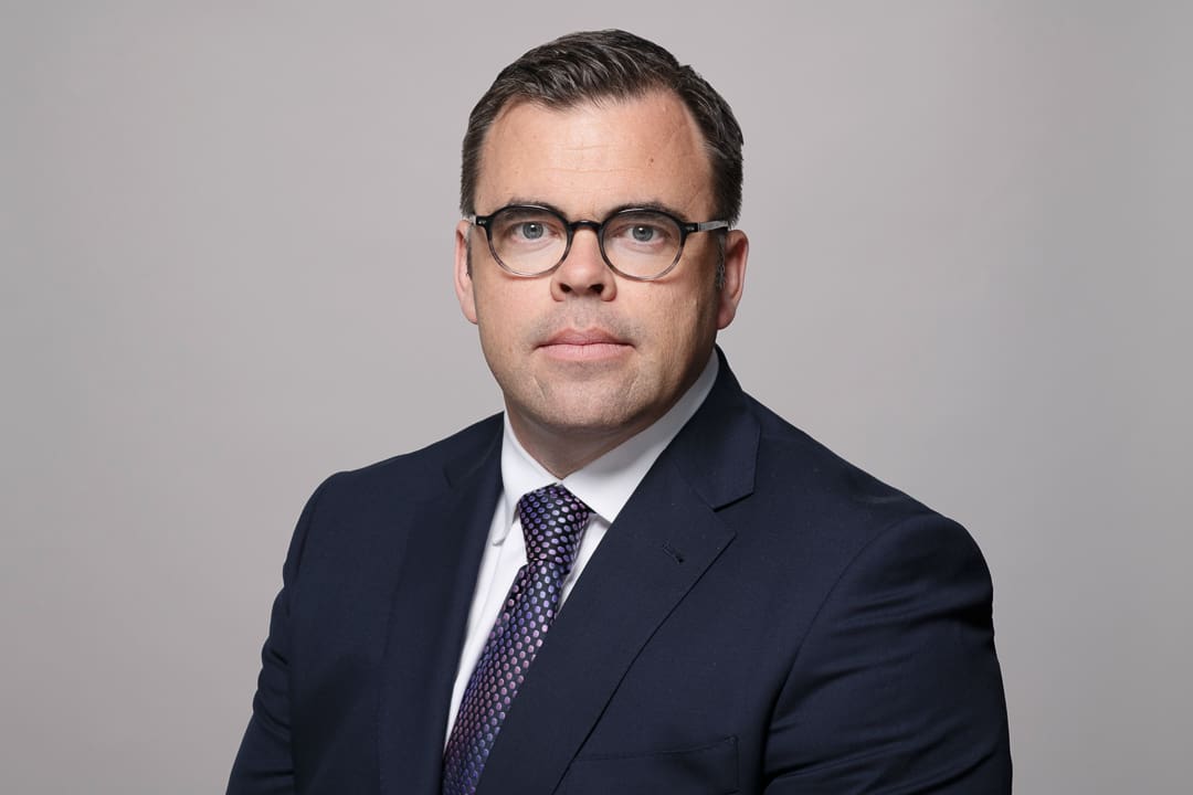 Melbourne barrister headshot of man with a serious expression, suit and glasses.