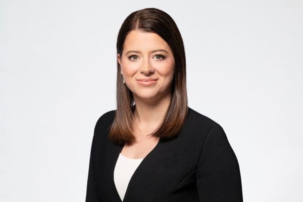 Melbourne barrister headshot of woman wearing black and white, smiling to camera.