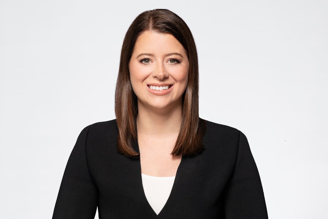 Melbourne barrister headshot of woman wearing black and white, smiling to camera.