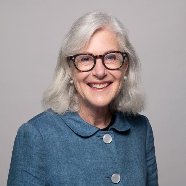 Professional headshot for a Melbourne Barrister, wearing a blue button up jacket and glasses.