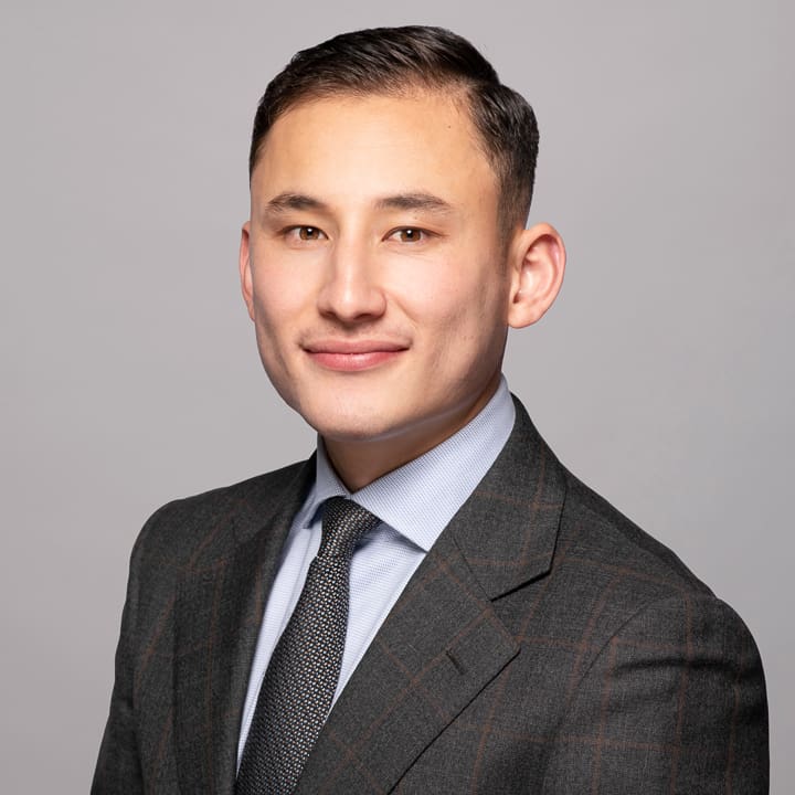 Melbourne LinkedIn headshot for local barrister, wearing a grey checked suit, smiling to camera.